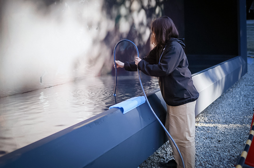 建物に水を注入する洛スタッフ 建物内の池