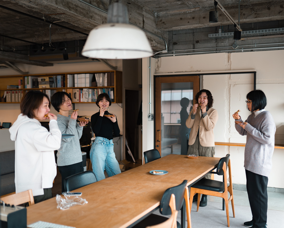 ピザに群がる女子一同。京都のリノベーション 株式会社洛のスタッフ