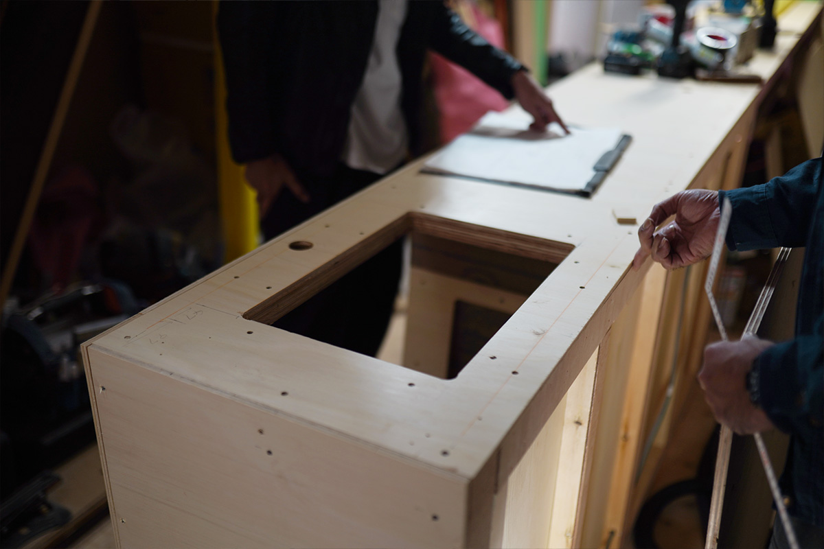 京都のネイルサロンリノベーション改装現場で製作中の木製カウンター、寸法確認の打ち合わせ風景