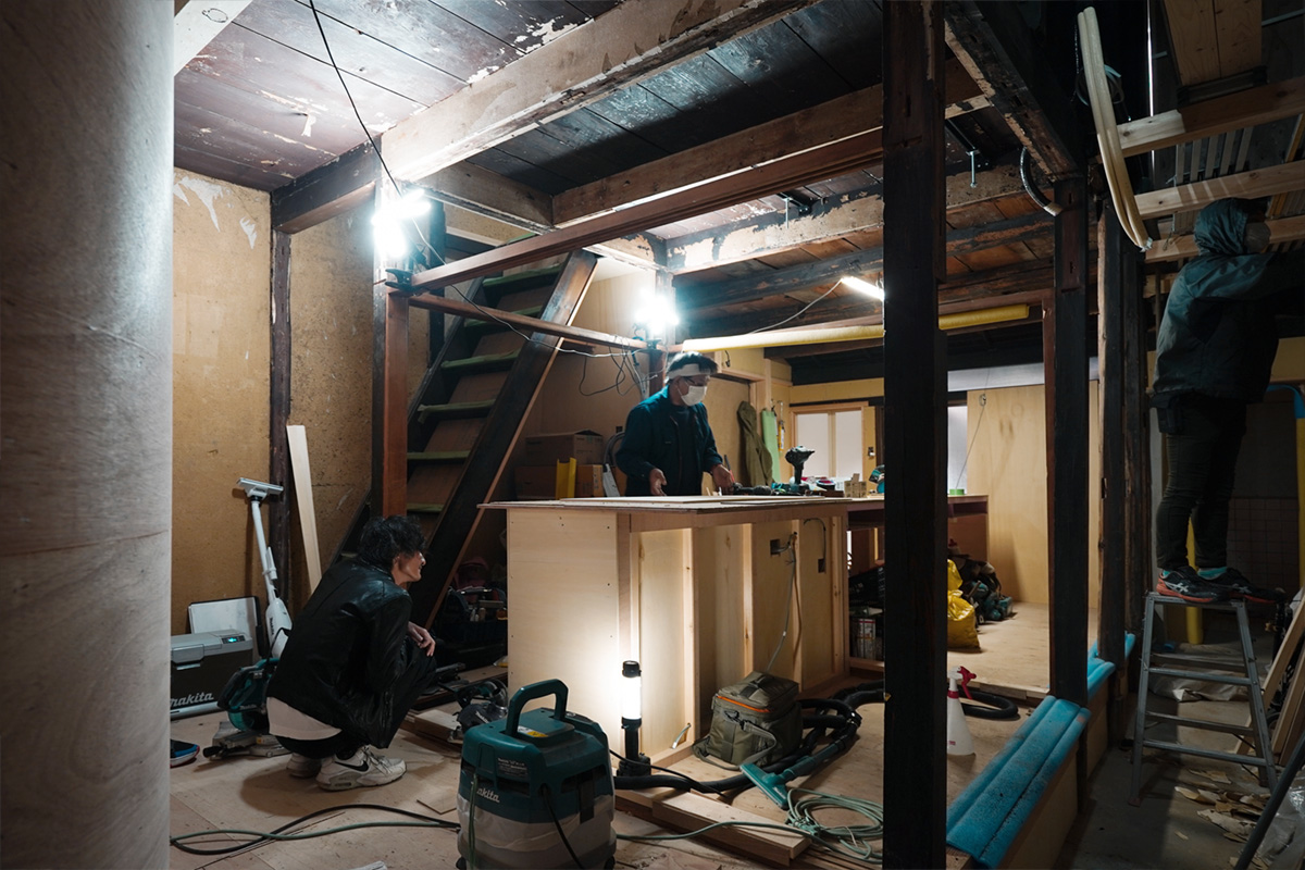 東山区の町家リノベーション現場で進む木工事、職人がカウンターを施工している様子
