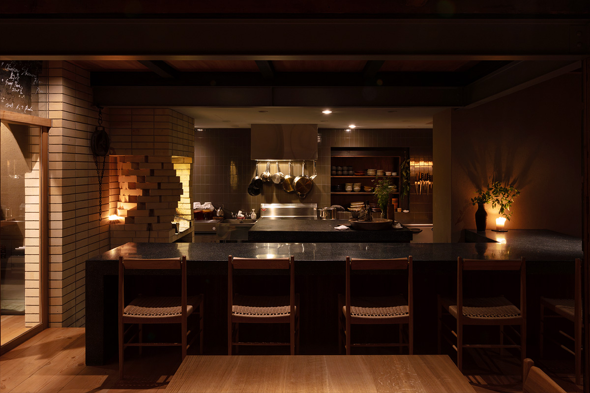 店舗左官研ぎ出しカウンターが配置された店内　料理を引き立てる建築