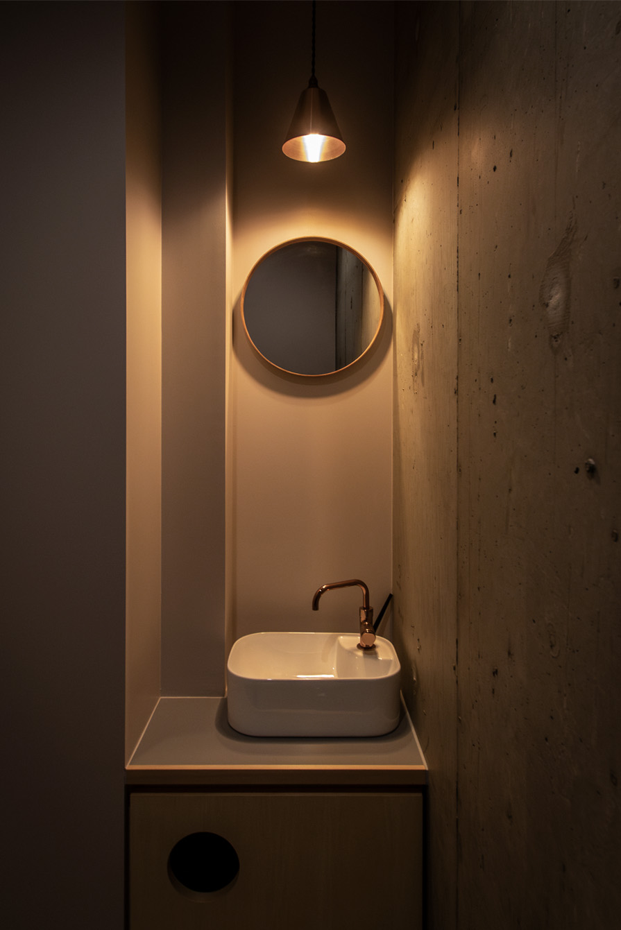 店舗洗面所デザイン。丸鏡とペンダント照明